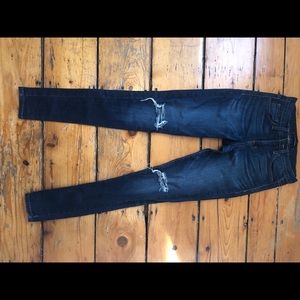 Dark denim jeans with slits in the knee